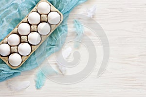 Easter decoration Ã¢â¬â white eggs and Milticolor bird feathers. Top view, close up, flat lay on white wooden background